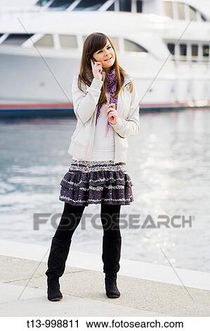 Attractive young woman is using a cellular phone View Large Photo Image Stock Image - Attractive young woman is using a cellular phone. Fotosearch