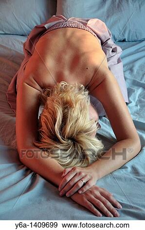 Attractive young woman lying on bed View Large Photo Image Stock Photo - Attractive young woman lying on bed. Fotosearch