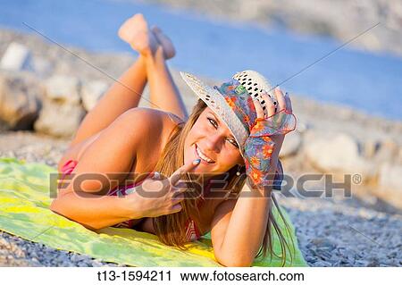 Attractive young woman lying on the beach View Large Photo Image Stock Image - Attractive young woman lying on the beach. Fotosearch
