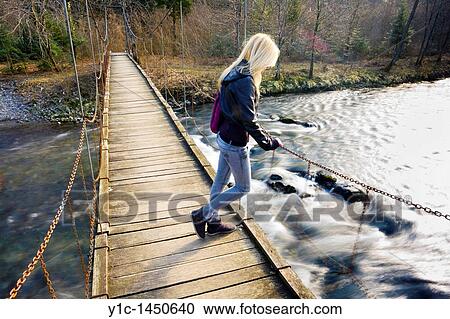 Attractive young woman on a hanging footbridge View Large Photo Image Stock Image - Attractive young woman on a hanging footbridge. Fotosearch