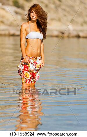 Attractive young woman on the beach holding her long pants dry View Large Photo Image Picture - Attractive young woman on the beach holding her long pants dry. Fotosearch