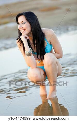Attractive young woman on the beach smiling View Large Photo Image Stock Photo - Attractive young woman on the beach smiling. Fotosearch