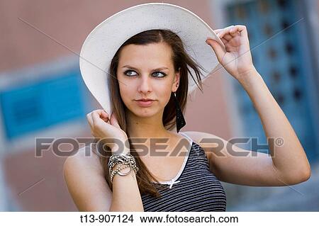 Attractive young woman outdoors hodling her White hat View Large Photo Image Picture - Attractive young woman outdoors hodling her White hat. Fotosearch