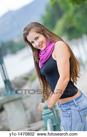 Stock Image - Attractive young woman posing on a sea promenade. Fotosearch