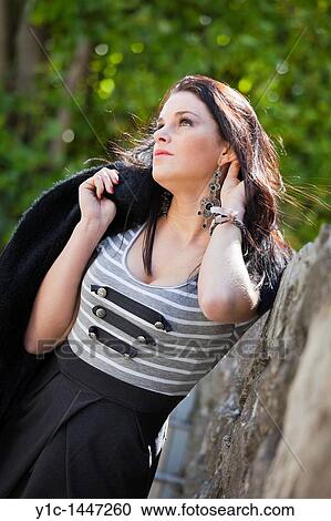 Stock Image - Attractive young woman resting in the park. Fotosearch