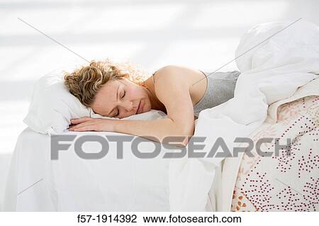 Attractive young woman sleeping in her bed View Large Photo Image Stock Image - Attractive young woman sleeping in her bed. Fotosearch