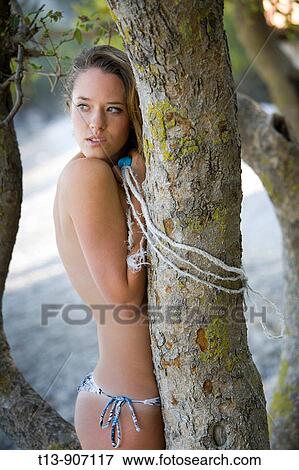 Attractive young woman topless shy behind tree View Large Photo Image Stock Photo - Attractive young woman topless shy behind tree. Fotosearch