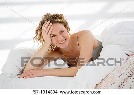 Attractive young woman waking up in her bed View Large Photo Image Picture - Attractive young woman waking up in her bed. Fotosearch