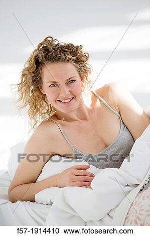 Attractive young woman waking up in her bed View Large Photo Image Stock Image - Attractive young woman waking up in her bed. Fotosearch
