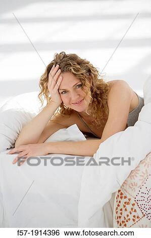Attractive young woman waking up in her bed View Large Photo Image Stock Photograph - Attractive young woman waking up in her bed. Fotosearch