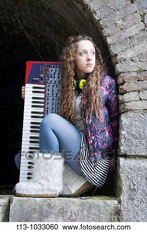 Attractive young woman with an electric keyboard musical instrument between her legs View Large Photo Image Stock Image - Attractive young woman with an electric keyboard musical instrument between her legs. Fotosearch