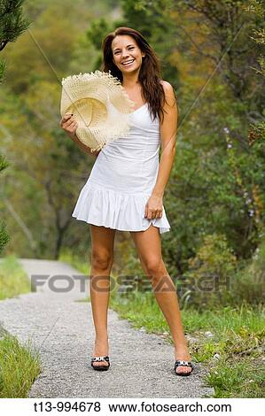 Stock Photo - Attractive young woman with fluffy Summer hat. Fotosearch