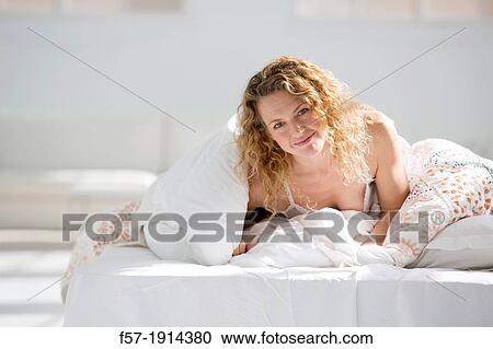 Attractive young woman wrapped in her quilt in bed View Large Photo Image Stock Image - Attractive young woman wrapped in her quilt in bed. Fotosearch