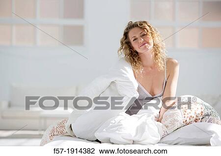 Attractive young woman wrapped in her quilt in bed View Large Photo Image Stock Image - Attractive young woman wrapped in her quilt in bed. Fotosearch