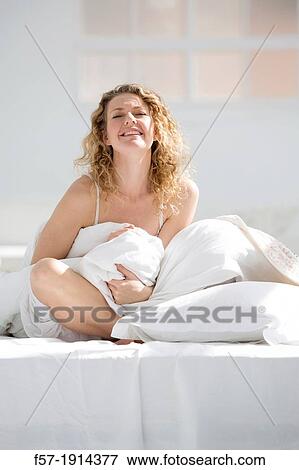 Attractive young woman wrapped in her quilt in bed View Large Photo Image Stock Photo - Attractive young woman wrapped in her quilt in bed. Fotosearch