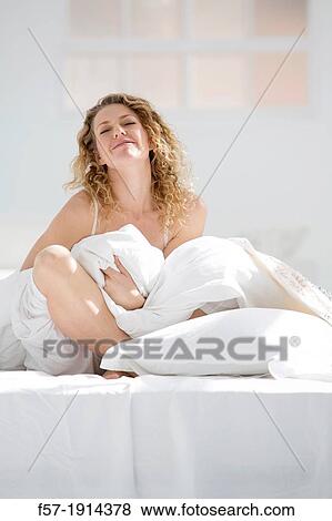 Attractive young woman wrapped in her quilt in bed View Large Photo Image Stock Photo - Attractive young woman wrapped in her quilt in bed. Fotosearch