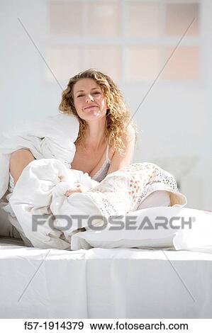 Attractive young woman wrapped in her quilt in bed View Large Photo Image Stock Photo - Attractive young woman wrapped in her quilt in bed. Fotosearch