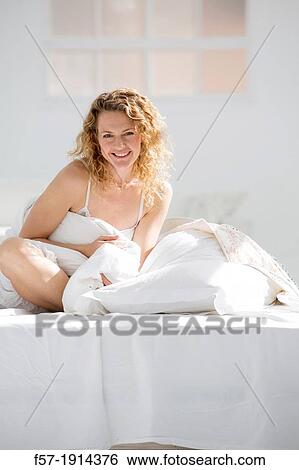 Attractive young woman wrapped in her quilt in bed View Large Photo Image Stock Photograph - Attractive young woman wrapped in her quilt in bed. Fotosearch