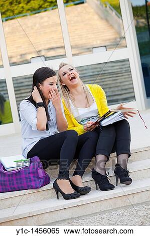 Attractive young women are sitting on low steps and looking at album photos, laughing View Large Photo Image Stock Photography - Attractive young women are sitting on low steps and looking at album photos, laughing. Fotosearch