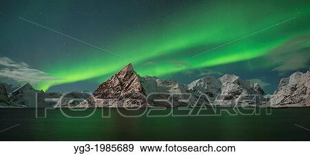 Aurora Borealis - Northern Lights fill sky over Olstind mountain peak and reflect in fjord, Toppoya, Lofoten Islands, Norway View Large Photo Image Stock Photo - Aurora Borealis - Northern Lights fill sky over Olstind mountain peak and reflect in fjord, Toppoya, Lofoten Islands, Norway. Fotosearch
