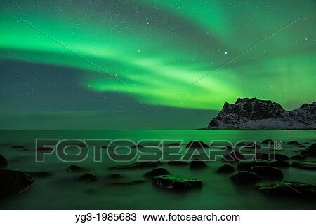 Stock Image - Aurora Borealis - Northern Lights over sea at Utakleiv, Vestv? goy, Lofoten Islands, Norway. Fotosearch