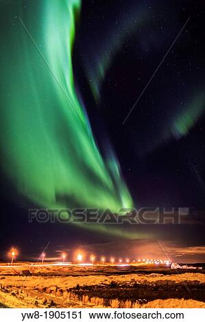 Stock Image - Aurora Borealis or Northern Lights, Iceland Northern lights over the highway and farmhouse, Alftanes, Iceland. Fotosearch