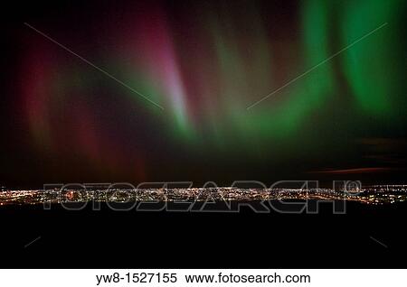 Stock Photography - Aurora Borealis over City Lights Digital composite of city lights and aurora borealis. Fotosearch