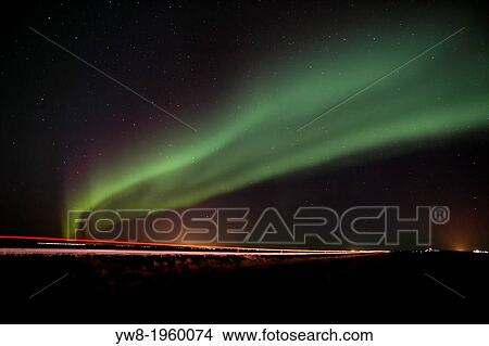 Picture - Aurora Borealis over road by country farms, Iceland.. Fotosearch