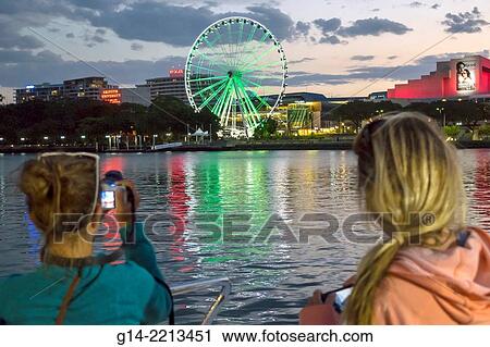 Australia, Queensland, Brisbane, South Bank, The Brisbane Wheel, Ferris, Brisbane River, Queensland Performing Arts Centre, center, dusk, night, CityCat, ferry, boat, TransLink, public transportation, passengers, riders. View Large Photo Image Stock Image - Australia, Queensland, Brisbane, South Bank, The Brisbane Wheel, Ferris, Brisbane River, Queensland Performing Arts Centre, center, dusk, night, CityCat, ferry, boat, TransLink, public transportation, passengers, riders.. Fotosearch