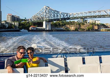 Australia, Queensland, Brisbane, Brisbane River, Story Bridge, CityCat, ferry, boat, public transportation, passengers, riders, TransLink, QueenslandFerries, man, Asian, woman, couple, smartphone, taking picture. View Large Photo Image Stock Photo - Australia, Queensland, Brisbane, Brisbane River, Story Bridge, CityCat, ferry, boat, public transportation, passengers, riders, TransLink, QueenslandFerries, man, Asian, woman, couple, smartphone, taking picture.. Fotosearch