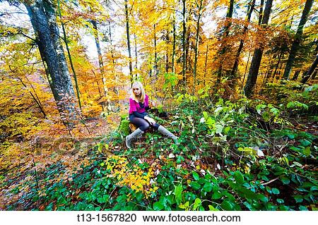 Stock Image - Autumn forest colors and a young woman. Fotosearch