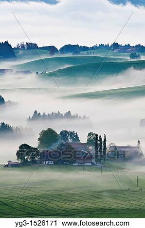 Autumn mist clears from rolling hills of Allgaeu region as near village of Eisenberg, Bavaria, Germany View Large Photo Image Stock Image - Autumn mist clears from rolling hills of Allgaeu region as near village of Eisenberg, Bavaria, Germany. Fotosearch