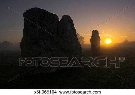 Picture - Avebury at sunrise on a misty morning, Avebury is the largest stone circle in the world, it is 427m in diameter covers an area of 28 acres and is situated in Wiltshire, England, UK. Fotosearch
