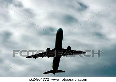 Stock Image - avi? n volando en un dia nuvoso. Fotosearch