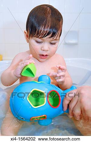 Stock Image - Baby at the tub playing with toy. Fotosearch