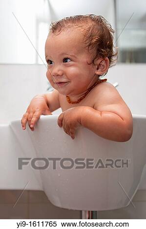 Stock Photography - Baby bathing in sink. Fotosearch