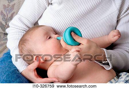 Baby boy (5 month old) getting nose cleaning by mom using a nose sucker View Large Photo Image Stock Photo - Baby boy (5 month old) getting nose cleaning by mom using a nose sucker. Fotosearch