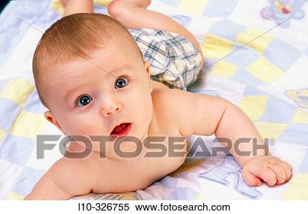 Baby boy almost rolls over onto back while laying on quilt View Large Photo Image Stock Photography - Baby boy almost rolls over onto back while laying on quilt. Fotosearch