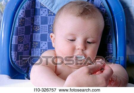 Baby boy eats a spponful of single grain rice cereal View Large Photo Image Stock Photo - Baby boy eats a spponful of single grain rice cereal. Fotosearch
