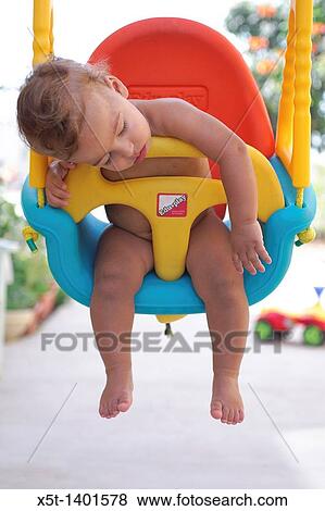 Stock Photo - Baby boy fast asleep on a swing. Fotosearch