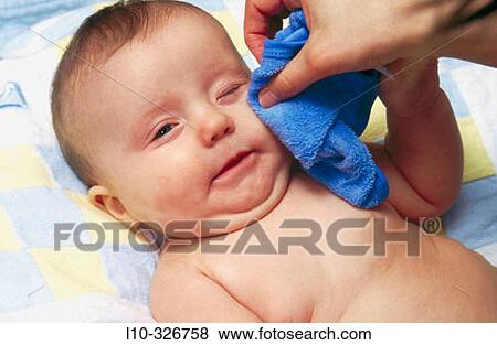 Stock Photo - Baby boy getting his face washed with blue wash cloth. Fotosearch
