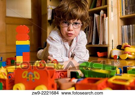 Baby boy three years old with glasses and funny face, scowling and playing with plastic cars and blocks, Madrid View Large Photo Image Picture - Baby boy three years old with glasses and funny face, scowling and playing with plastic cars and blocks, Madrid. Fotosearch