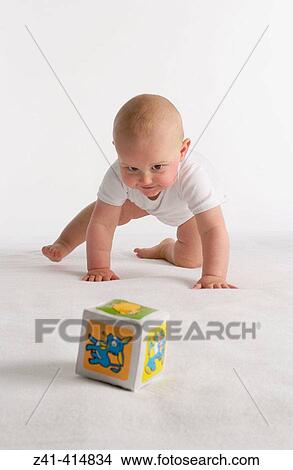 Baby crawling towards a toy View Large Photo Image Picture - Baby crawling towards a toy. Fotosearch