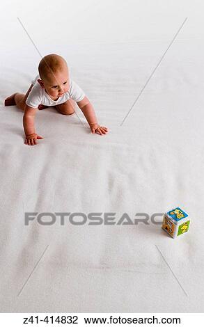 Baby crawling towards a toy View Large Photo Image Stock Image - Baby crawling towards a toy. Fotosearch