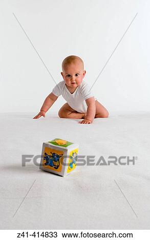 Baby crawling towards a toy View Large Photo Image Stock Image - Baby crawling towards a toy. Fotosearch