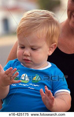 Stock Photography - Baby discovers his hands. Fotosearch
