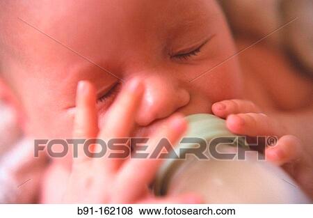 Stock Photo - Baby drinking from bottle. Fotosearch