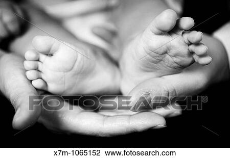 Stock Image - Baby feet and parents? hands. Fotosearch