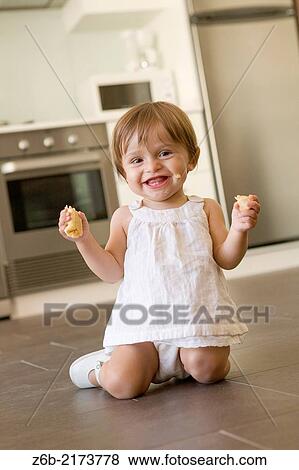 Baby-girl, 11 Months, 2 Teeth, Eating, fruit, banana, Kitchen, oven, microwave, fridge, tiles View Large Photo Image Stock Photo - Baby-girl, 11 Months, 2 Teeth, Eating, fruit, banana, Kitchen, oven, microwave, fridge, tiles. Fotosearch