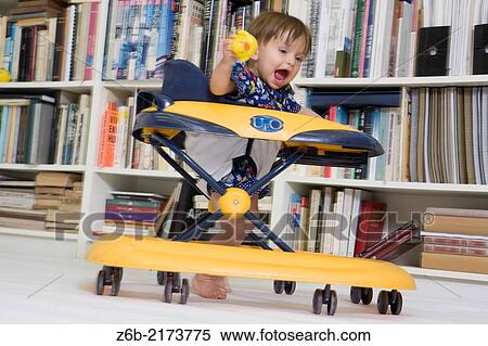 Baby girl, 11 Months, Movement, Walker, wheels, shouting, Indoors, Bookshelves, rubber duck, Toddler View Large Photo Image Stock Photography - Baby girl, 11 Months, Movement, Walker, wheels, shouting, Indoors, Bookshelves, rubber duck, Toddler. Fotosearch